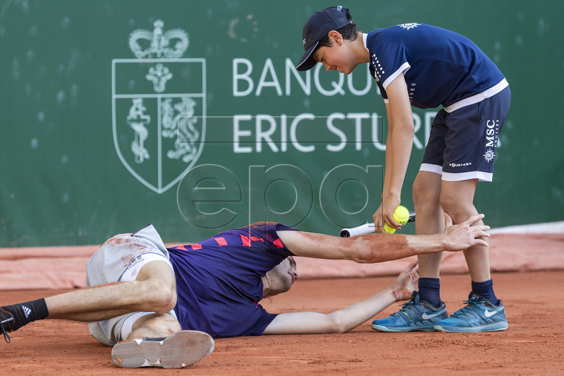Alexander Zverev of Germany clings on to a ball boy's legs after falling during his quarter final match against Alexander Zverev of Germany at the Geneva Open tennis tournament in Geneva, Switzerland, 23 May 2019.  EPA-EFE/MARTIAL TREZZINI