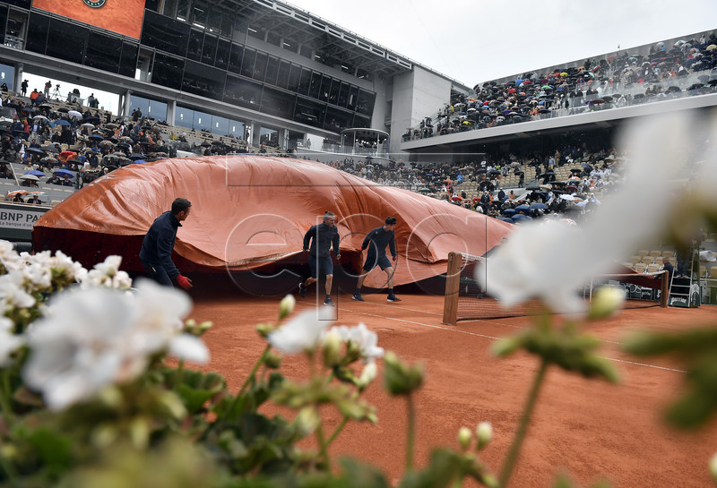 Staff covers the Court Philippe Chatrier as rain interrupts Dominic Thiem of Austria playing Novak Djokovic of Serbia during their men?s semi final match during the French Open tennis tournament at Roland Garros in Paris, France, 07 June 2019.  EPA-EFE/JULIEN DE ROSA