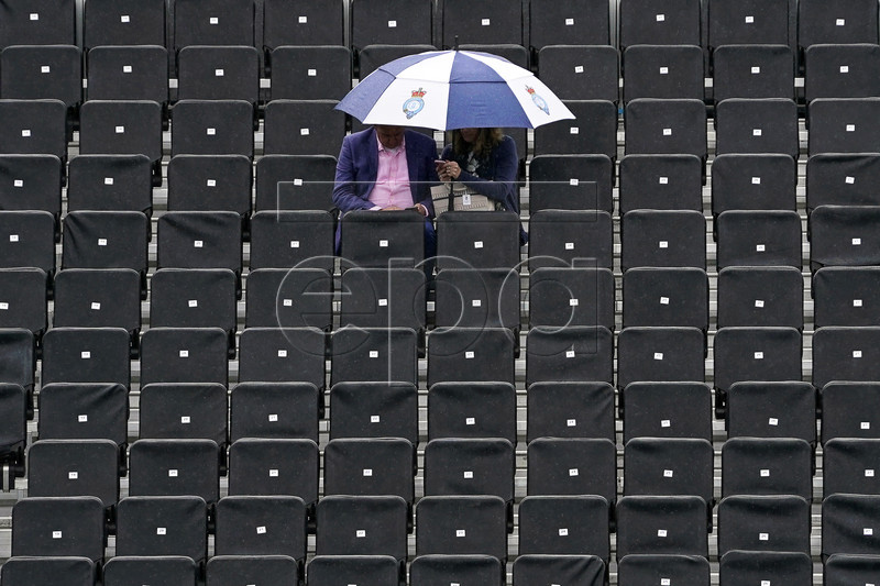 Spectators protect themselves from the rain during the second day of the Fever Tree Championships at Queen's Club in London, Britain, 18 June 2019. EPA-EFE/WILL OLIVER