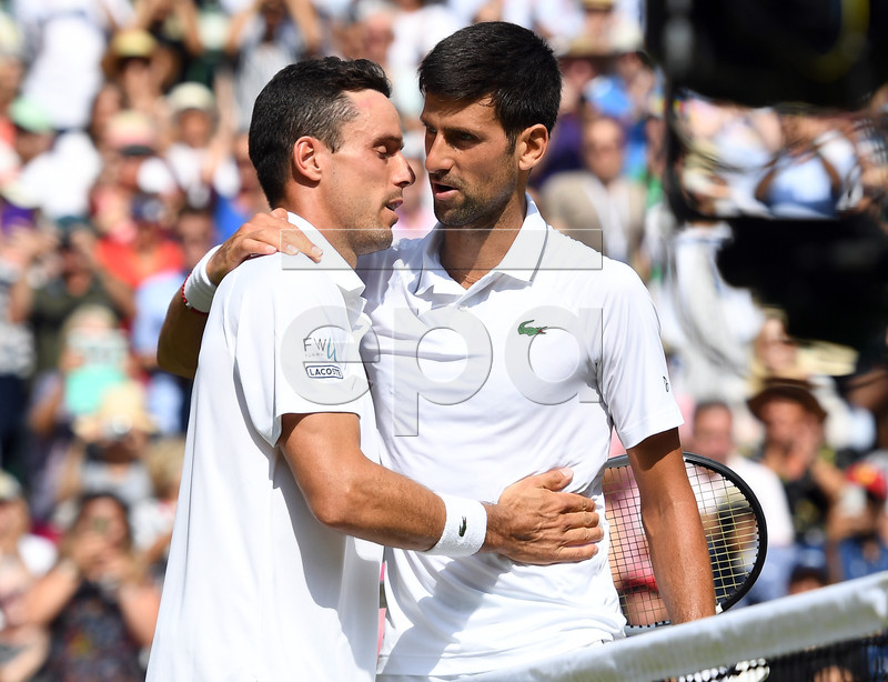 Novak Djokovic of Serbia (R) at the net with Roberto Bautista Agut of Spain whom he defeated in their semi final match during the Wimbledon Championships at the All England Lawn Tennis Club, in London, Britain, 12 July 2019. EPA-EFE/ANDY RAIN EDITORIAL USE ONLY/NO COMMERCIAL SALES