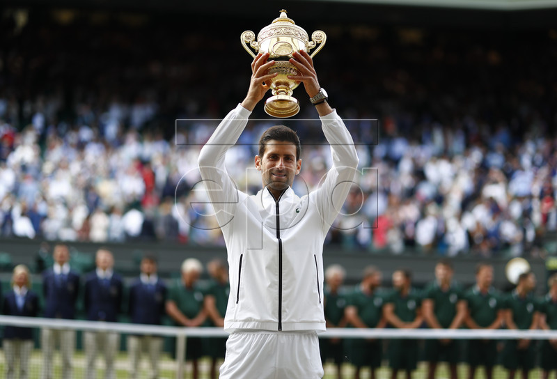 Novak Djokovic of Serbia hoists the championship trophy after defeating Roger Federer of Switzerland in the men's final of the Wimbledon Championships at the All England Lawn Tennis Club, in London, Britain, 14 July 2019. EPA-EFE/NIC BOTHMA EDITORIAL USE ONLY/NO COMMERCIAL SALES