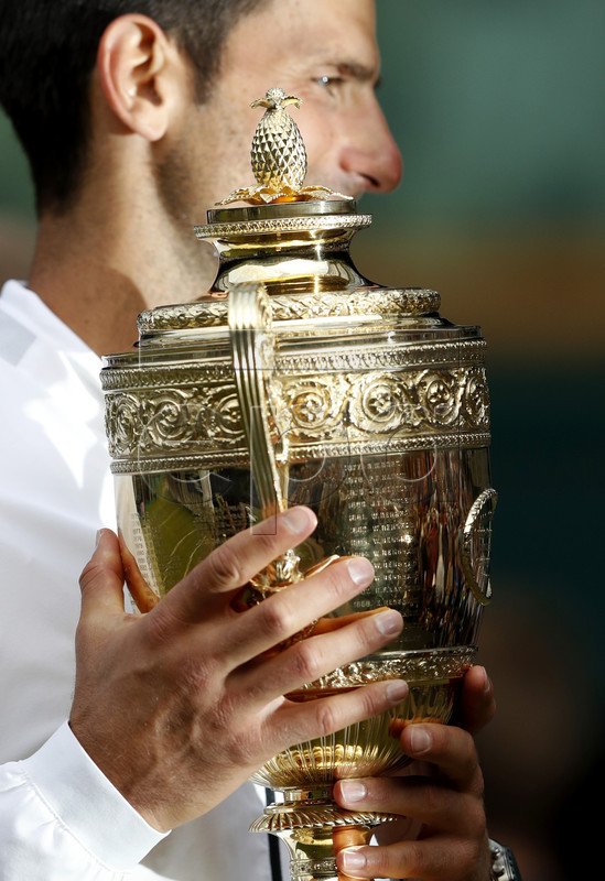 Novak Djokovic of Serbia celebrates with the trophy after winning against Roger Federer of Switzerland during their Men's final match for the Wimbledon Championships at the All England Lawn Tennis Club, in London, Britain, 14 July 2019. EPA-EFE/ADRIAN DENNIS / POOL EDITORIAL USE ONLY/NO COMMERCIAL SALES